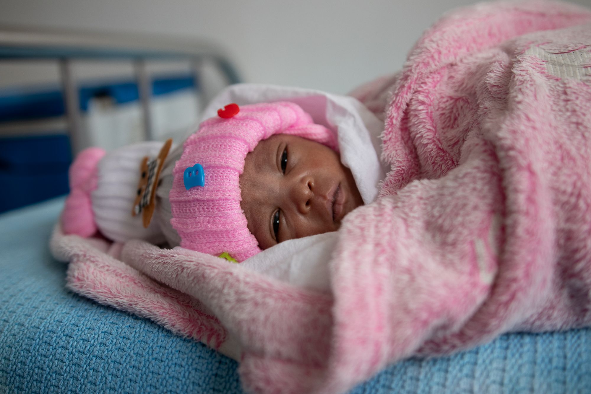 Newborn Hadassa (2 weeks) is wrapped in a blanket on a hospital bed in Nairobi, Kenya